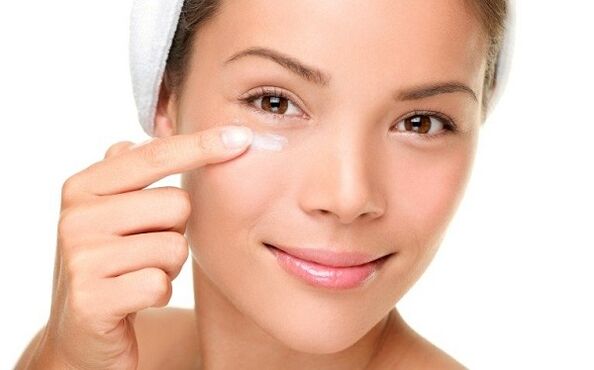 by applying a rejuvenating cream to the skin around the eyes